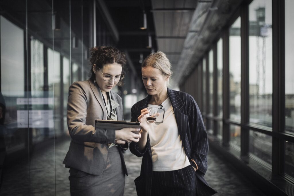 To kvinder læser noget på en tablet på arbejde